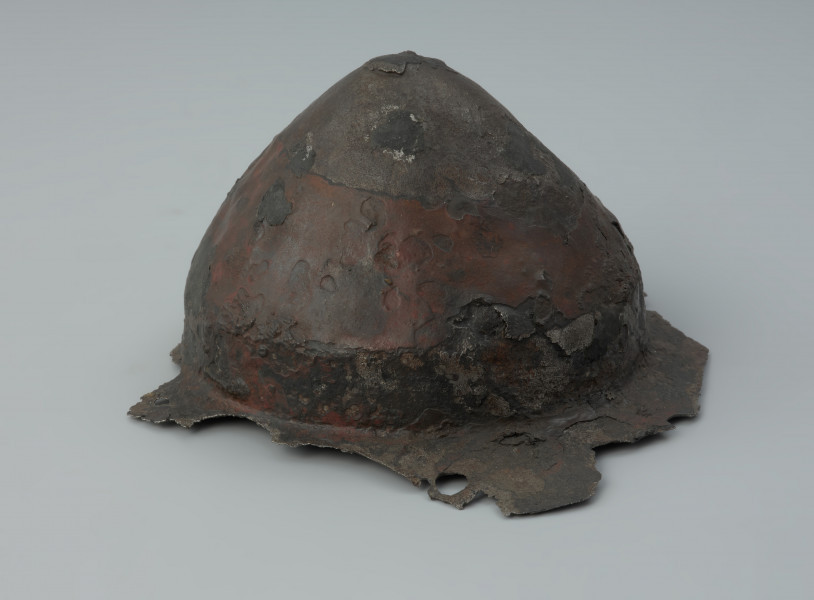 Żelazne umbo ze zniszczonym brzegiem. - Ujęcie z lewej strony. Żelazne umbo ze zniszczonym brzegiem.