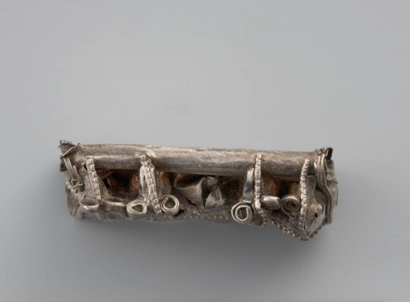 ozdoba - Ujęcie przodu kaptorgi z góry. Kaptorga prostokątna zdobiona filigranem i motywem zoomorficznym.