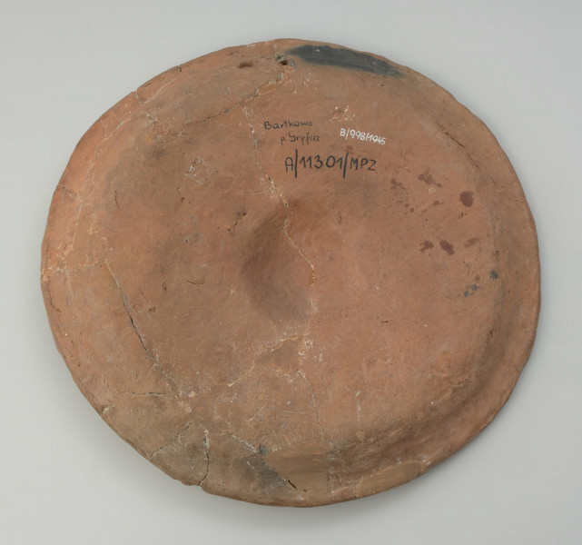 naczynie, talerz - Ujęcie z dołu. Talerz gliniany bogato dekorowany plastycznymi motywami solarnymi.