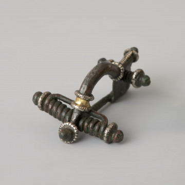 Zapinka z brązu ze srebrnymi aplikacjami - Ujęcie z przodu z lewej strony. Zapinka z brązu ze srebrnymi aplikacjami.