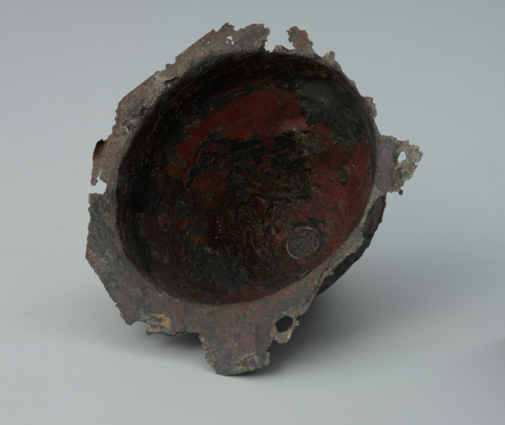 Żelazne umbo ze zniszczonym brzegiem. - Ujęcie z dołu. Żelazne umbo ze zniszczonym brzegiem.