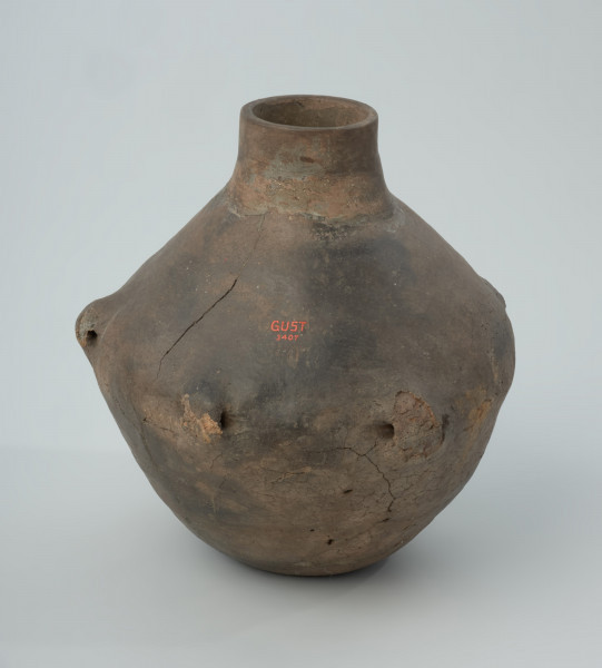 Naczynie gliniane - Ujęcie z tyłu; Amfora, zapewne o cylindrycznej szyjce (rekonstrukcja) i dwustożkowatym brzuścu, z pięcioma uchami na załomie, nie posiada żadnych zdobień.