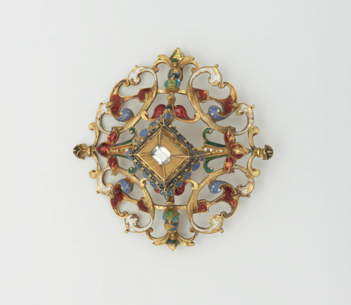 biżuteria, ozdoby - Ujęcie z przodu. Ażurowy klejnot z kołpaka z diamentem, zdobiony barwną emalią.