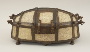 relikwiarz św. Korduli - Ujęcie z przodu. Relikwiarz św. Korduli to owalna szkatuła wykonana z 22 płytek z poroża łosia zdobionych w skandynawskim stylu Mammen, którego głównym motywem był element poskręcanych bestii w towarzystwie wątków roślinnych, stosowany od połowy X do połowy XI wieku. Płytki połączono ze sobą za pomocą pozłacanej miedzianej taśmy, której zwieńczenia mają postać smoczych łbów. Dno relikwiarza wykonano z drewna dębowego, a stało ono na sześciu brązowych nóżkach.