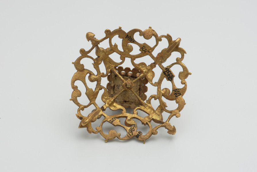 biżuteria, ozdoby - Ujęcie z tyłu. Ażurowy klejnot z kołpaka z diamentem, zdobiony barwną emalią.