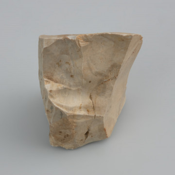 rdzeń wiórowy jednopiętowy - ujęcie z tyłu; Pięta rdzenia uformowana i naprawiana kilkoma odbiciami (tzw. świeżona). Boki i tył rdzenia silnie przekształcone na skutek długotrwałego użytkowania. Prawy bok naprawiony serią odbić od strony grzbietu. Frontalna odłupnia pokryta płaskimi negatywami wiórów odbitych miękkim tłukiem. Na skutek zbyt silnego uderzenia rdzeń pękł na dwie części. Zabytek pokryty jest jasną patyną oraz rdzawymi plamami, które są efektem zalegania w środowisku o odczynie lekko kwaśnym i dużej zawartości żelaza.