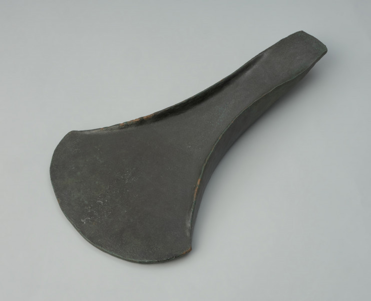 siekierka typu Ubiedrze; siekierka typu wschodniobałtyckiego - Ujęcie z przodu z góry. Masywna siekierka z brązu z podniesionymi brzegami. Okaz ma wachlarzowato uformowane ostrze i wąski, prosto zakończony obuch. Na ostrzu brak śladów użycia.