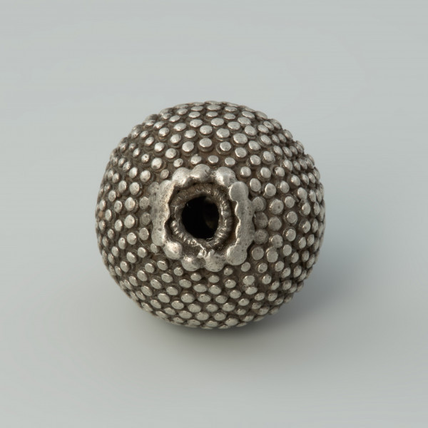 guz, biżuteria, ozdoba - Ujęcie spodu. Guz srebrny okrągłego kształtu zdobiony granulacją.