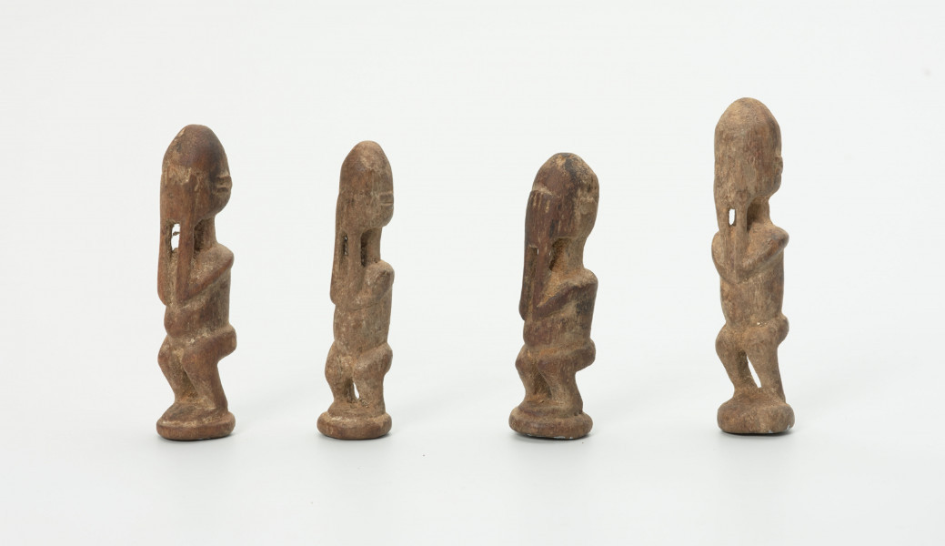 rzeźba - Ujęcie z prawego boku; Zestaw składa się z czterech małych, drewnianych, stojących figurek przedstawiających postacie ludzkie – najprawdopodobniej przodków. Wszystkie mają zakryte dłońmi twarze.