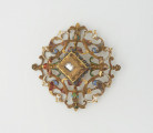 biżuteria, ozdoby - Ujęcie z przodu. Ażurowy klejnot z kołpaka z diamentem, zdobiony barwną emalią.