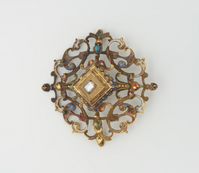 biżuteria, ozdoby - Ujęcie z góry. Ażurowy klejnot z kołpaka z diamentem, zdobiony barwną emalią.