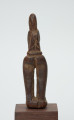rzeźba - Ujęcie z tyłu. Figurka - postać kobiety. Nacisk położono na pośladki i uda, które zostały bardzo uwydatnione. Brak rąk.
