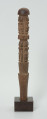 drewniana, rzeźbiona pałka - Ujęcie z przodu. Okrągła, drewniana pałka z płytko rzeźbionymi dwoma rzędami postaci ludzkich. W każdym rzędzie zaznaczonych zostało czterech przodków, bez wyraźnie zaznaczonych cech płciowych.