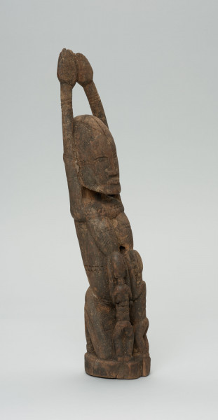 rzeźba - Ujęcie ze skosu z lewej; Kobieta przedstawiona w pozycji klęczącej z rękoma uniesionymi do góry. Karmi dzieci (bliźnięta) dzieci ukazane od tyłu.