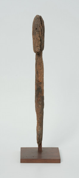 Ujęcie z przodu; Rzeźba. Figura - Nommo - drewniana pałka zakończona głową o cechach antropomorficznych. Umieszczona na drewnianej podstawie.
