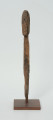 Ujęcie z przodu; Rzeźba. Figura - Nommo - drewniana pałka zakończona głową o cechach antropomorficznych. Umieszczona na drewnianej podstawie.
