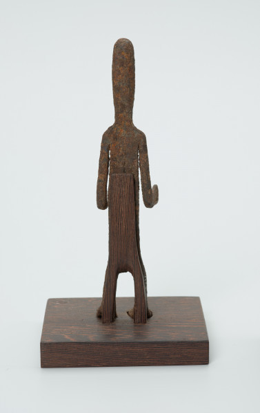 rzeźba - Ujęcie z tyłu. Figurka - postać mężczyzny. Zarysowana tylko sylwetka, ugięte kolana, Ręce zgięte w łokciach. Stanowi wyposażenie grobu.