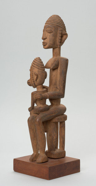 rzeźba - Ujęcie ze skosu z prawej strony; Kobieta ma owalną, wydłużoną twarz oraz długie, zwisające uszy. Rysy twarzy proporcjonalne, z cienkim kształtnym nosem, brwiami oraz wypukłymi oczami i ustami.