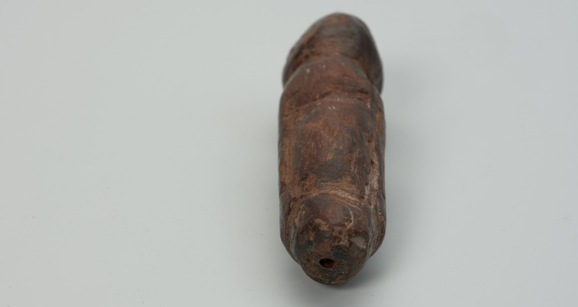 Drewniana figurka zwierzęcia - Ujęcie z przodu w poziomie. Drewniana figurka zwierzęcia. Forma bardzo uproszczona, z bryły symbolicznie wyodrębnione: głowa, tylne i przednie kończyny oraz ogon.