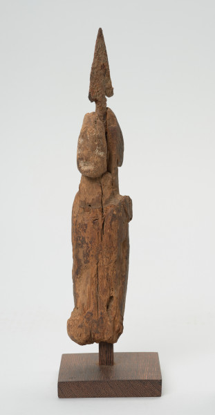 rzeźba - Ujęcie z przodu. Uproszczona postać ludzka, z wetkniętym grotem strzały. Stanowi część wyposażenia grobu.