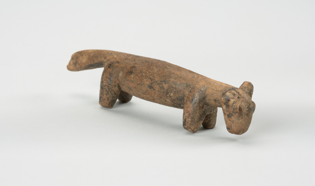 rzeźba - Ujęcie przodu skosem w prawą stronę. Rzeźba z drewna zwierzęcia przypominającego szakala.