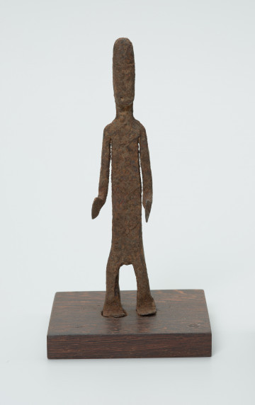 rzeźba - Ujęcie z przodu. Figurka - postać mężczyzny. Zarysowana tylko sylwetka, ugięte kolana, Ręce zgięte w łokciach. Stanowi wyposażenie grobu.