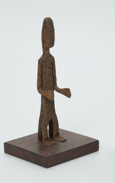 rzeźba - Ujęcie przodu skosem w prawą stronę. Figurka - postać mężczyzny. Zarysowana tylko sylwetka, ugięte kolana, Ręce zgięte w łokciach. Stanowi wyposażenie grobu.