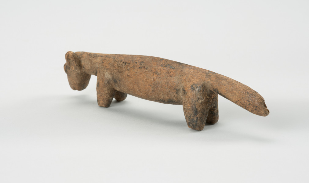 rzeźba - Ujęcie tyłu skosem w lewą stronę. Rzeźba z drewna zwierzęcia przypominającego szakala.