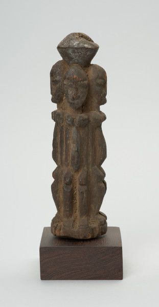 rzeźba - Ujęcie lewej strony rzeźby. Drewniana rzeźba czterech postaci zwróconych do siebie plecami. Każdy z nich zwrócony jest w inną stronę świata. Postaci wyrzeźbione schmeatycznie. Zarysowana duża, podłużna głowa, szczupłe ramiona, tułów, krótkie nogi ugięte w kolanach.