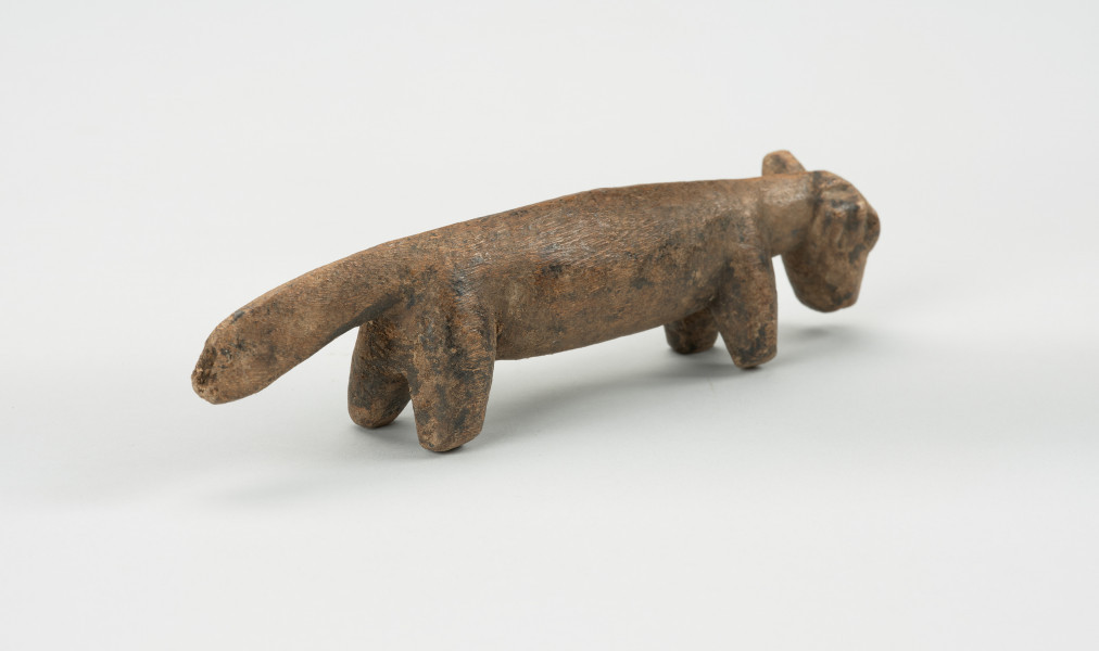 rzeźba - Ujęcie z tyłu skosem w prawą stronę.  Rzeźba z drewna zwierzęcia przypominającego szakala.