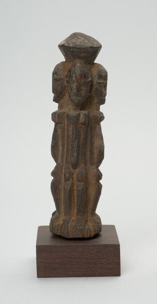 rzeźba - Ujęcie z tyłu. Drewniana rzeźba czterech postaci zwróconych do siebie plecami. Każdy z nich zwrócony jest w inną stronę świata. Postaci wyrzeźbione schmeatycznie. Zarysowana duża, podłużna głowa, szczupłe ramiona, tułów, krótkie nogi ugięte w kolanach.