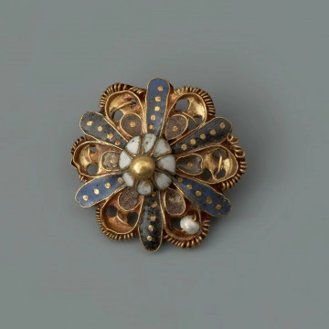 pontalik z sarkofagu księcia Franciszka I (1577-1620) - Ujęcie z przodu. Pontalik w kształcie kwiatowej rozetki z płatkami zdobionymi perełkami nawleczonymi na drut oraz emalią komórkową, inkrustowaną złotem. Płatki z perełkami otoczone są skręconym drutem. Środek kwiatka kopulasty, zbudowany z ośmiu białych płatków, zwieńczony złotą kulką. Na odwrocie centralnie przymocowane uszko z drutu.