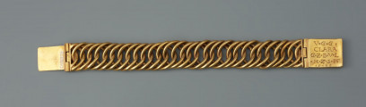 bransoleta z sarkofagu księcia Franciszka I (1577 - 1620) - Ujęcie z przodu. Bransoleta wykonana ze skręconych, przenikających się ogniw, w tzw. splocie pancerzowym. Na prostokątnych zapinkach dziewięciopolowy herb Księstwa Pomorskiego trzymany przez dzikich mężów, pierwotnie emaliowany. Na spodzie klamry ryta inskrypcja, pierwotnie emaliowana: V.G.G. / CLARA / G.Z.B.V.L. / H.Z.S.Pō /15.96. Na bocznych ściankach wykonana w tej samej technice inskrypcja: V.G.G. FRANTZ / H.Z.S.Pom.