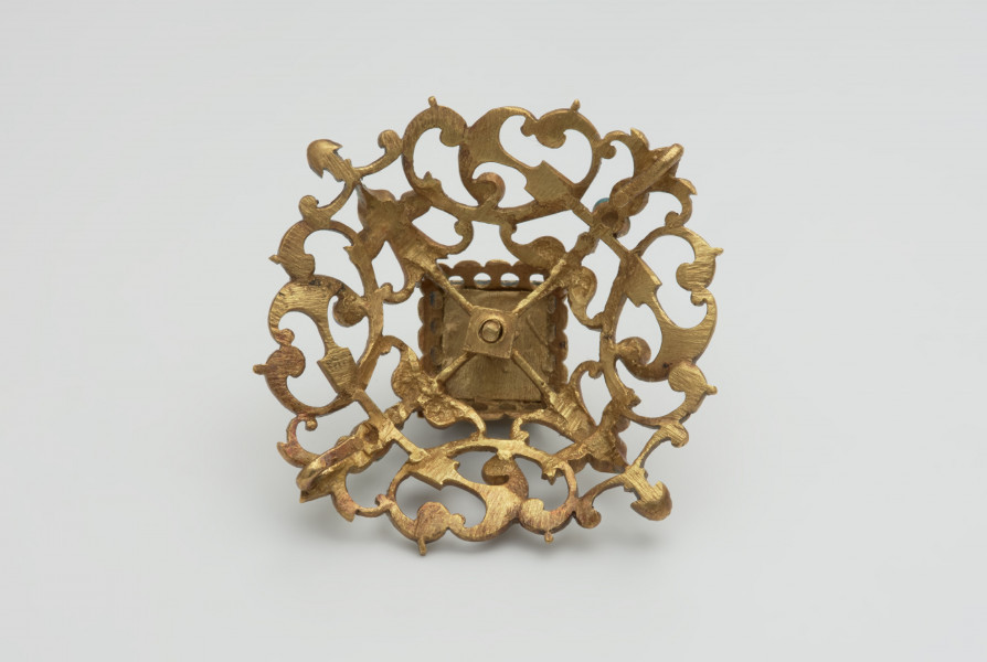 biżuteria, ozdoby - Ujęcie z tyłu. Ażurowy klejnot z kołpaka z diamentem, zdobiony barwną emalią.