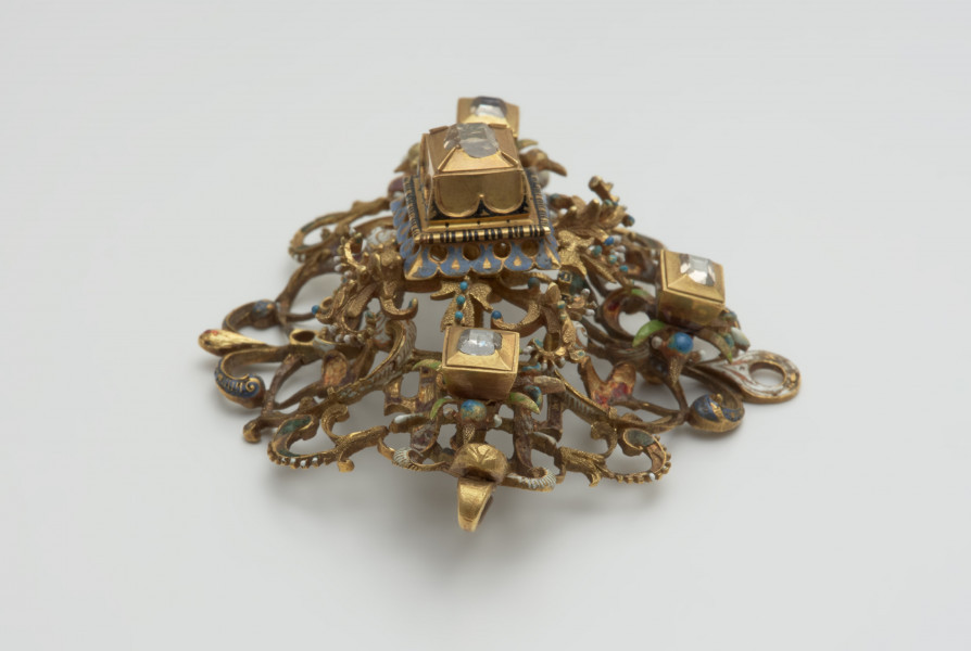 nakrycia głowy, biżuteria, ozdoby - Ujęcie z boku od góry. Klejnot z kołpaka w kształcie rombu, ażurowy, zdobiony emalią i kasztami z diamentami.