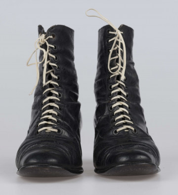 E/11811/ML - Buty odświętne, z czarnej licowej skóry. Wewnątrz płócienna podszewka. Obcas słupowaty wys. 5 cm. Podeszwy ze skóry. Cholewka wys. 10 cm, dopasowana do nogi, z przodu sznurowana. Nosek zwężony, na końcu ścięty. Wykrój podeszew w obu butach identyczny – lewy równa się prawemu.