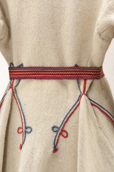 Sukmana kobieca, odświętna, szyta ręcznie z samodziałowego, folowanego sukna w kolorze białym. Nieodcinana w talii, przody bez zapięcia. Rękawy długie, lekko zwężone ku dołowi. Na bokach poniżej talii wstawione trójkątne kliny, które tworzą fałdy. W szwach łączących przody z klinami – tzw. ślepe kieszenie. Ozdobiona czerwonym i granatowym sznureczkiem wełnianym: na kołnierzyku, na przodzie,  dole rękawów oraz na bokach poniżej talii i przy kieszeniach. Często przepasywana była wełnianą krajką.