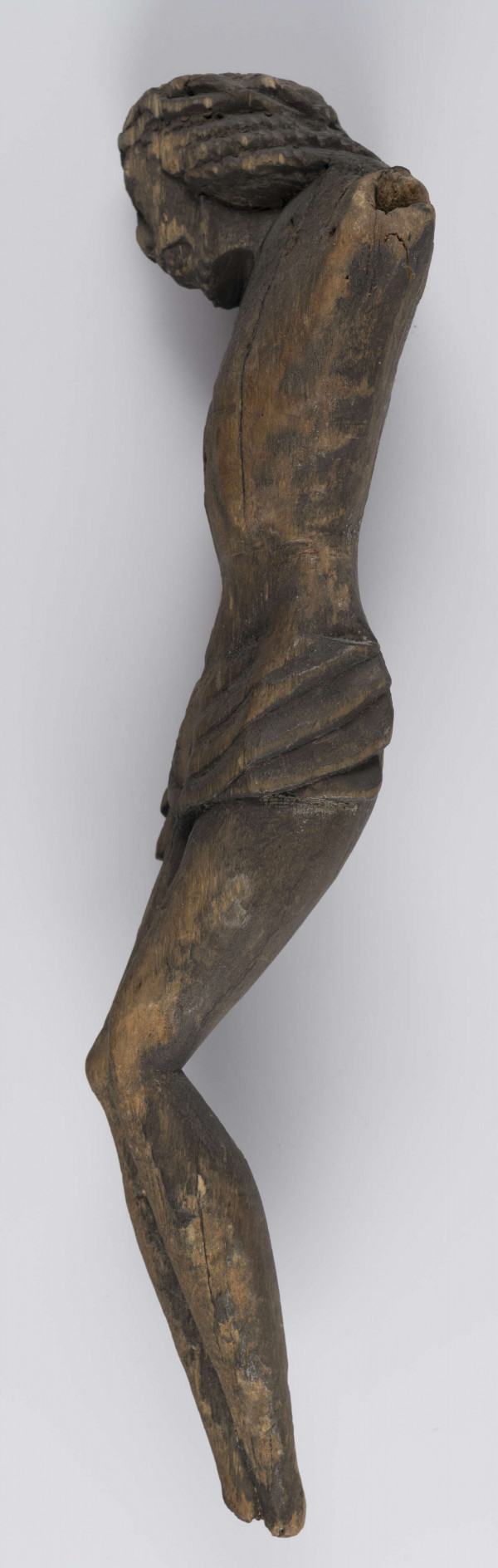 E/336/ML - Chrystus Ukrzyżowany. Stan rzeźby zły, brak rąk i stóp. Głowa lekko pochylona w prawo. Twarz o wyrazistych rysach. Na głowie korona cierniowa spleciona z wałeczków, luźno. Perizonium podkreślone łukowatymi żłobieniami. Z prawej strony płat materiału stanowiący perizonium - związany w fantazyjny węzeł. Nogi proste. Wyodrębnione uda, kolana i łydki. Stopy złączone.
