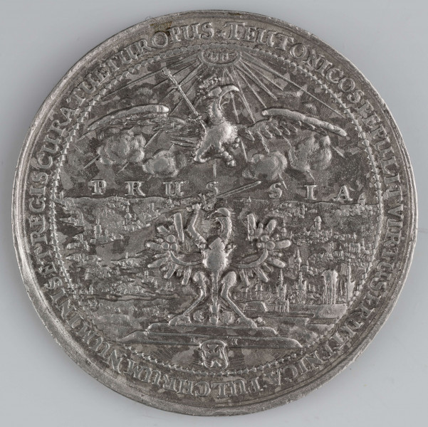 N/1523/ML - AV. W ziarnistej obwódce na schodkowym postumencie Orzeł pruski nad nim napis PRUS - SIA i orzeł koronny, a wyżej gloria z hebrajskim napisem: Jahwe. W tle równina z miastami, zamkiem i rzekami. Na dole mała tarcza Zakonu Krzyżackiego rozdziela litery I - H, monogram autora medalu. W otoku napis poprzedzony rozetką:
TEUTONICOS PEPULIT VIRTUS PRUTENICA : PULCHRUM NUMINIS ET REGIS CURA TUETUR OPUS

RV. Poniżej małego herbu Gdańska dwunastowierszowy napis;
GEDANI / ANNOS . ANTE . DUCENTOS / SUB . AUGUSTIS . (D) . CASIMIRI / AUSPICIIS . UNIVERSA . PROPE / CUM . PRUSSIA . AB . INFANDA / CRUCIGEROR . TYRANNIDE . LIBE / RATE . TERTIUM . LIBERTATIS / SUAE . SECULUM . REGNANTE / IOANNE . CASIMIRO / FELICITER . INCHOANTIS / MEMORIA / AN . C I ) I ) L I V
