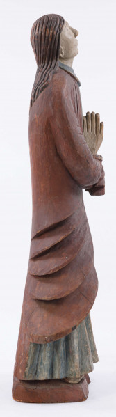 E/16137/ML - Rzeźba drewniana, pełna, polichromowana, przedstawiająca św. Anny. Na postumencie w kształcie nieregularnego prostokąta, zakomponowana postać świętej, w długiej sukni, układanej w pionowe fałdy. U góry fałdy są drobniejsze, u dołu fałdy grubsze, pod szyją kołnierzyk w kształcie półokrągłej plisy. Na sukni kubraczek w kolorze brązowym, sięgający do połowy łydki, o połach zaokrąglonych u dołu. Kubrak z długimi rękawami jest dopasowany w czasie. Z przodu do pasa podkreślony jest dość wąskimi pionowymi żłobieniami, od pasa szerszymi biegnącymi ukośnie fałdami, zaś na rękawach ukośnymi nieregularnymi żłobieniami. Ręce złożone na piersiach do modlitwy. Głowa wzniesiona lekko do góry i lekko przechylona w prawo. Włosy brązowe, zaznaczone z przedziałkiem pośrodku, opadające na plecy, podkreślone żłobieniami. Nos prosty wydatny, usta wąskie, oczy owalne czarne, brwi cienkie łukowate czarne. Twarz i ręce pokryte cielistą farbą. Widoczne uszy. Spod sukni widoczne bose stopy.

Konserwacja: 1988 r.