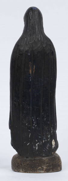 E/6363/ML - Rzeźba z drewna lipowego, polichromowana farbą olejną. Zakomponowana w jednym kawałku drewna na postumencie o formie owalnej z płaskorzeźbionym motywem dwóch skrzyżowanych gałęzi. Postać stojąca przedstawia Matkę Boską Różańcową. Twarz owalna, głęboko osadzone oczy, prosty i szeroki nos, małe pełne usta. Ręce zgięte w łokciach: duże dłonie złożone do modlitwy. Na przedramieniu prawej ręki brązowy różaniec o płaskich paciorkach, zakończony dużym krzyżem. Postać odziana w białą prostą suknię, gładko wykończoną pod szyją i przewiązaną granatową szarfą. Na głowie granatowa szata spełniająca jednocześnie rolę peleryny spływającej z ramion ku dołowi i spowijającej całą postać.