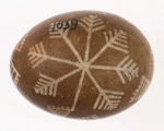 E/1039/ML - Technika batik. Podział podłużny na 2 części. Motyw gwiazdy, krzyża, swastyki. Barwa tła brązowa, barwa motywu biała i ceglasta.