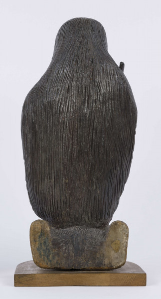 E/6353/ML - Figura drewniana, zakomponowana na postumencie, polichromowana. Postać klęcząca przedstawia św. Onufrego. Twarz płaska, trójkątna, głęboko osadzone oczy, czarne źrenice. Szerokie łuki brwiowe łączą się z wydatnym prostym nosem. Wystające kości jarzmowe. Małe usta otacza bujny zarost: broda i wąsy łączące się z bujnymi włosami, otaczającymi całą postać – na podobieństwo płaszcza. Ręce zgięte w łokciach, uniesione ku górze, łączą się końcami palców w geście modlitwy. W nieproporcjonalnie dużych dłoniach biały różaniec zakończony dużym krzyżem. Nogi masywne z dużymi płaskimi stopami. Prawą dłonią podtrzymuje sękaty kostur. W partii pasa przepasany powrozem z węzłami. 