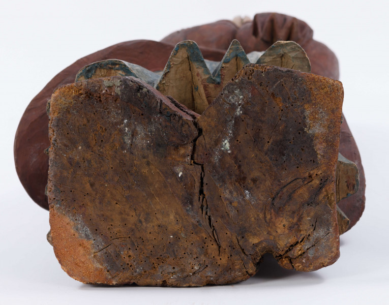 E/16137/ML - Rzeźba drewniana, pełna, polichromowana, przedstawiająca św. Anny. Na postumencie w kształcie nieregularnego prostokąta, zakomponowana postać świętej, w długiej sukni, układanej w pionowe fałdy. U góry fałdy są drobniejsze, u dołu fałdy grubsze, pod szyją kołnierzyk w kształcie półokrągłej plisy. Na sukni kubraczek w kolorze brązowym, sięgający do połowy łydki, o połach zaokrąglonych u dołu. Kubrak z długimi rękawami jest dopasowany w czasie. Z przodu do pasa podkreślony jest dość wąskimi pionowymi żłobieniami, od pasa szerszymi biegnącymi ukośnie fałdami, zaś na rękawach ukośnymi nieregularnymi żłobieniami. Ręce złożone na piersiach do modlitwy. Głowa wzniesiona lekko do góry i lekko przechylona w prawo. Włosy brązowe, zaznaczone z przedziałkiem pośrodku, opadające na plecy, podkreślone żłobieniami. Nos prosty wydatny, usta wąskie, oczy owalne czarne, brwi cienkie łukowate czarne. Twarz i ręce pokryte cielistą farbą. Widoczne uszy. Spod sukni widoczne bose stopy.

Konserwacja: 1988 r.