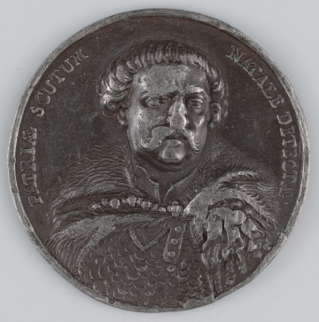 N/1535/ML - AV. Popiersie Sobieskiego: głowa na wprost, ramiona en trois - quarts w lewo. Po bokach w łukach napis:
PATRIAE SCUTUM - NATALE DETECTAE

RV. Pod wieńcem laurowym czternastowierszowy napis:
IOANNI SOBIESKI / MAGNO REGNI ET MILITIAE / MAGISTRO.  OB RUPTI FOEDE,, / RIS QUOD PATER AD CHOCI,, / MUM ICERAT VINDICTAM / IBIDEM DE HOSTE SUMPTAM. / EXERCITUM AD INTERNECIONEM / CAES UM CASTRA CAPTA. SPOLIA / ACTA VALACHIAM MOLDAVIAMQ / IN PROVINCIAM REDACTAS, / FINES REIPUB . AD DANUBIUM / PROLATOS . INFERIAS AVO / MATERNO MISSAS MEMORIA / SERVATA AETER . PUBL . 
Na dole związane palmy.