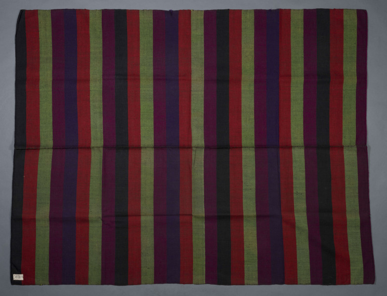 E/6798/ML - Tkanina pasiak, tkana splotem rządkowym. Osnowa lniana czarna, wątek wełniany w kolorach:  czerwony, buraczkowym, zielonym, czarnym i granatowym. Raport tworzą pasy o szer. 6,5 cm. 