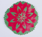 Wycinanka naklejona z zielonego i czerwonego papieru. Tło zielone o kształcie 8boku. Z czerwonego papieru wycięta 16ramienna o ramionach ażurowanych w serduszka i gwiazdkę.

