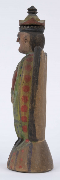 E/8100/ML - Rzeźba pełna wykonana z jednego kawałka drewna lipowego, polichromowana. Postać w hieratycznej postaci, w układzie frontalnym. Ręce wsparte na biodrach. Postać stoi na stożkowatym cokole. Na głowie korona z dwóch oddzielnych kawałków drewna, złączonych ozdobnym czopem drewnianym. Włosy czarne, ręce i twarz różowa, korona żółta z czerwonym obrzeżem, zwieńczenie czarne. Płaszcz stylizowany, przypominający skrzydła lub ornat, czarny. Szaty wewnętrzne żółte z czerwonymi plamkami. Wewnątrz długie, zielone z niebieskimi plamami. Buty czarne. Na piersiach duże otwarte serce zwieńczone czarnym krzyżem. Cokół w naturalnym kolorze drewna, ozdobiony pionowymi niebieskimi paskami i czerwonymi kropkami. Wym. cokołu: 13 x 10,5 cm. Sygnatura na spodzie (pisana): Jan Kaproń.