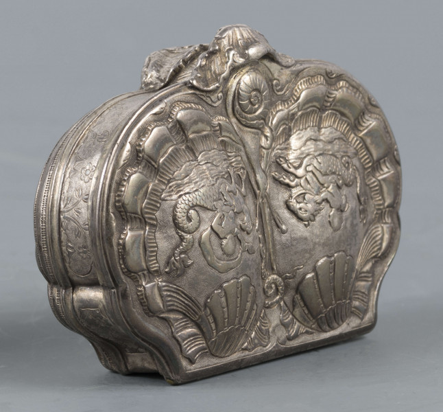 S/Mt/566/ML - Denko puklowane w formie dwóch złożonych symetrycznie muszli, zdobionych rzędami kampanuli i podobnie uformowane wieczko, z bogatszą dekoracją. Na powierzchni muszli relief przedstawiający dwa hipokampy z zakręconymi rybimi ogonami - prawy z głową konia, lewy z głowa orła - dosiadane przez putta. W polach między muszlami na dole slimak, u góry wąż. Ścianki boczne grawerowane : elementy pejzażu, ptak, królik, kwiaty i kratka regencyjna. Wnętrze złocone.
 Wewnątrz na denku i wieczku powtórzone punce ze znakami:
- miejska Paryża z 1. poł XVIII w. (litera S pod koroną
- złotnika o inicjałach 