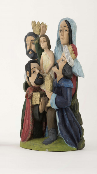 Rzeźba z drewna lipowego, technika strugania, polichromowana farbami plakatowymi. Na postumencie w kształcie nieregularnego owalu o wym. 23 x 13 x 1,5 cm, w kolorze seledynowym, zakomponowane zostały cztery postacie. W głębi z lewej strony postać króla (wys. 38 cm) w granatowej długiej szacie i zielonym płaszczu, z okrągłym kołnierzem. Król w lewej podniesionej ręce trzyma złotą koroną, w prawej – srebrny dzbanek. Z prawej strony postać Matki Boskiej (wys. 38,5 cm) z Dzieciątkiem (wys. 17 cm) w kremowej sukience, na prawym ręku. MB w czerwonej długiej sukni, zielonym płaszczu i niebieskiej chustce na głowie. Przed MB z lewej strony klęczy król (wys. 24,5 cm) w czerwonym płaszczu i czarnej sukni, który w rękach trzyma złotą szkatułkę. Z prawej strony klęczy król (wys. 28,5 cm) w granatowym płaszczu o niebieskim podbiciu i mankietach, brązowych spodniach, granatowych butach sięgających do połowy łydki. Na głowie ma złotą koronę na czerwonej czapce, otoczonej białym zawojem. W lewej ręce trzyma złotu kielich. 